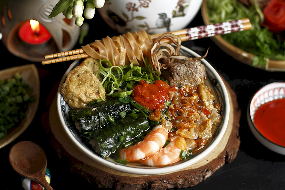It is a rich and savory noodle soup made with crab and a variety of fresh ingredients, known for its unique combination of flavors and textures